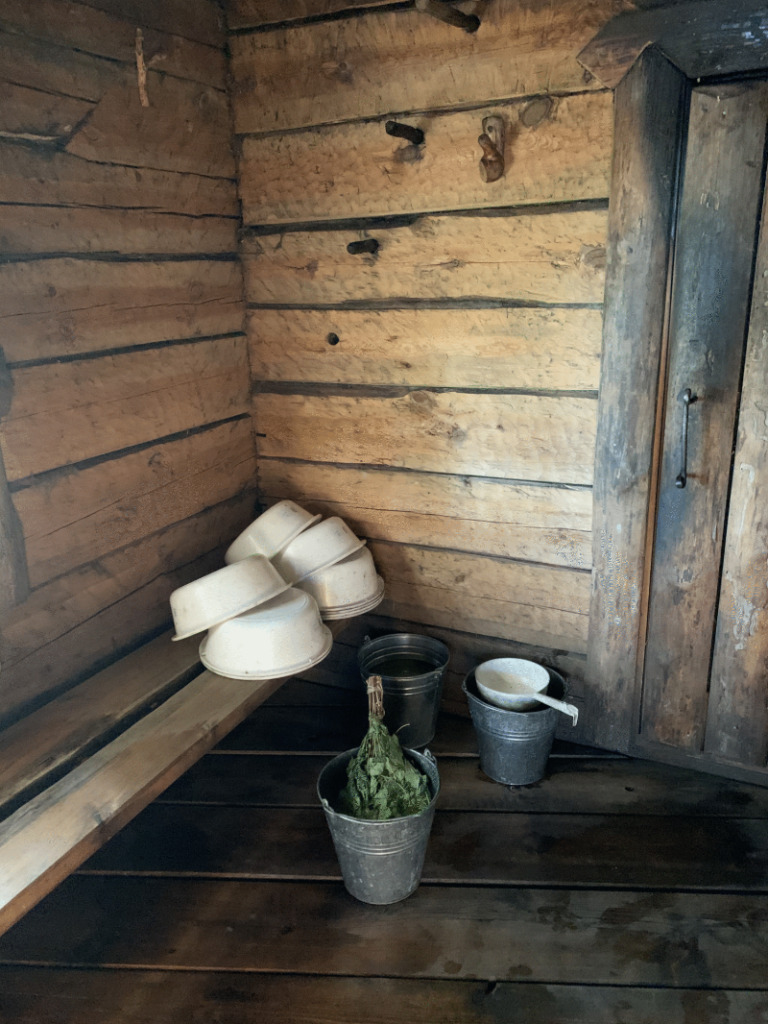 Traditional wooden sauna with a vihta in a bucket